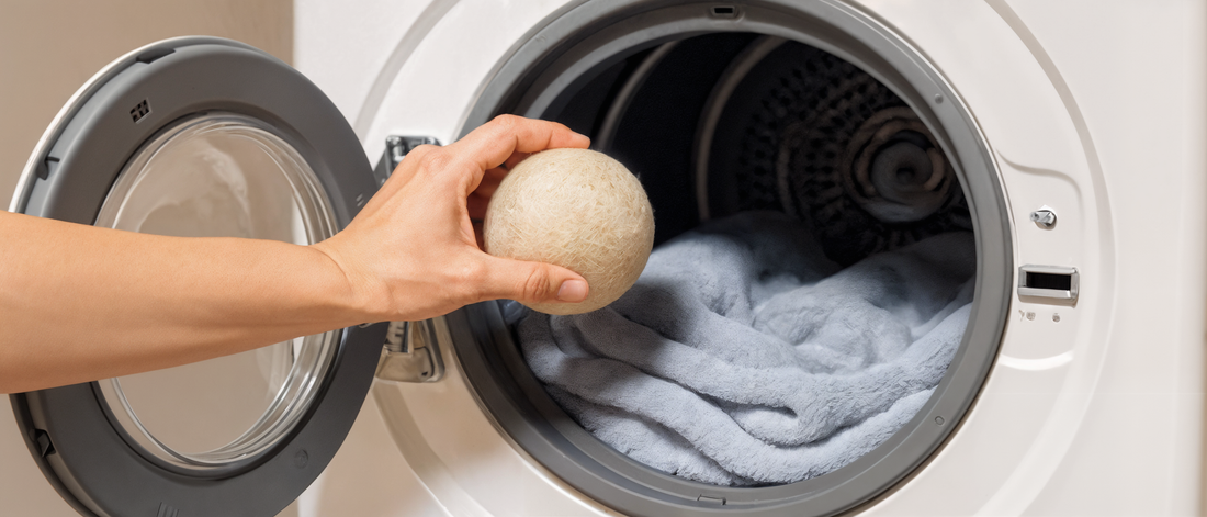 A wool dryer ball being added to a drum of towels