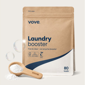 Laundry booster: kraft pouch of fragrance-free enzyme booster with its wooden measuring scoop and soap bubbles