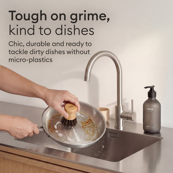 Cleaning Essentials: brush cleaning a pan at the sink, tough on grime and kind to dishes