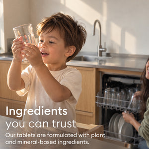 The Whole-Home Detox: child holding up a clean glass by the dishwasher, plant and mineral-based ingredients